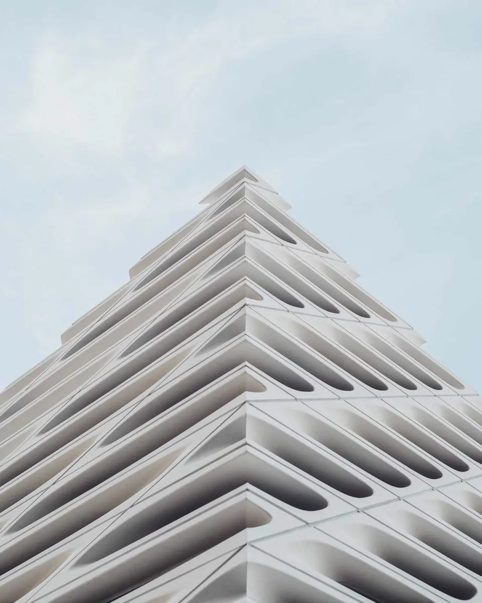 Esquina de um edifício branco em degraus contra um céu azul claro